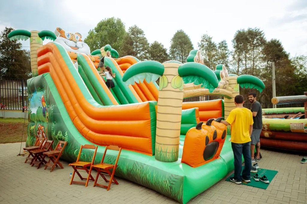 Crianças brincando nos brinquedos infláveis do espaço kids